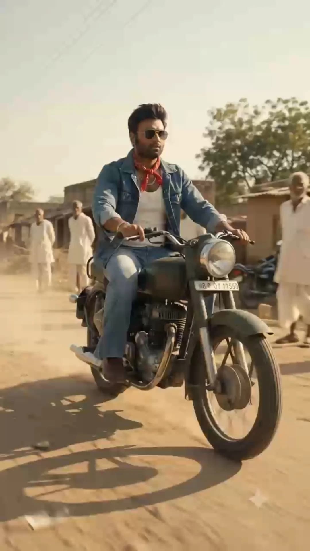 Young man in 1980s denim jacket riding a vintage Rajdoot bike through a village road, dhaba and old bazaar, 25-second AI montage made with Google Flow